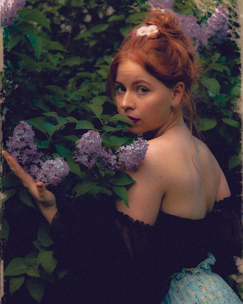 A Woman Posing near Lilac Flowers