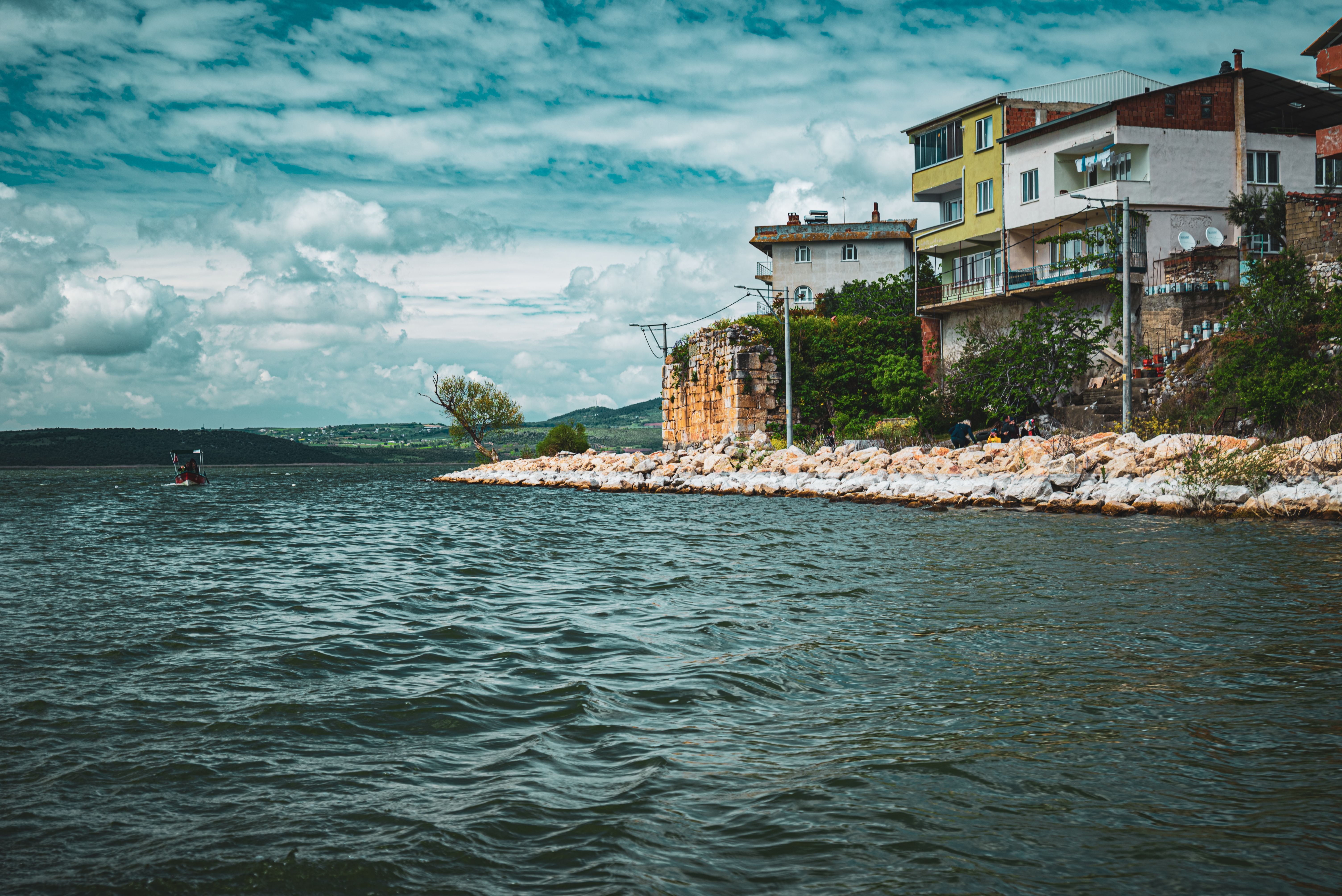 Charming coastal scene in Bursa, Turkey featuring buildings along the shore and a cloudy sky.