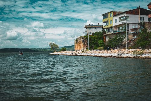 Free Charming coastal scene in Bursa, Turkey featuring buildings along the shore and a cloudy sky. Stock Photo