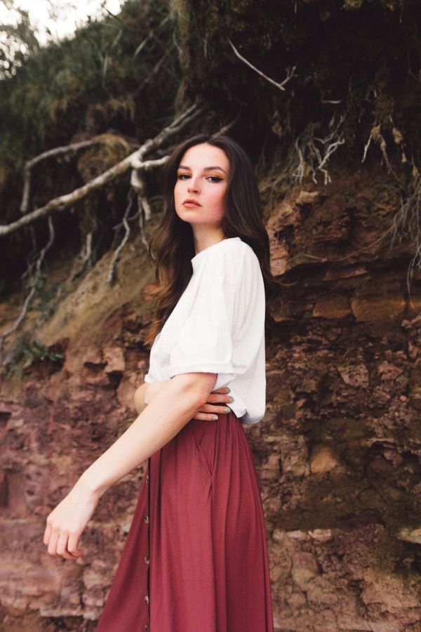 Woman in a burgundy satin skirt with a white tee