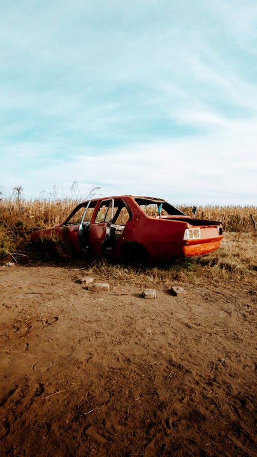 Red Abandoned Car on Brown Field