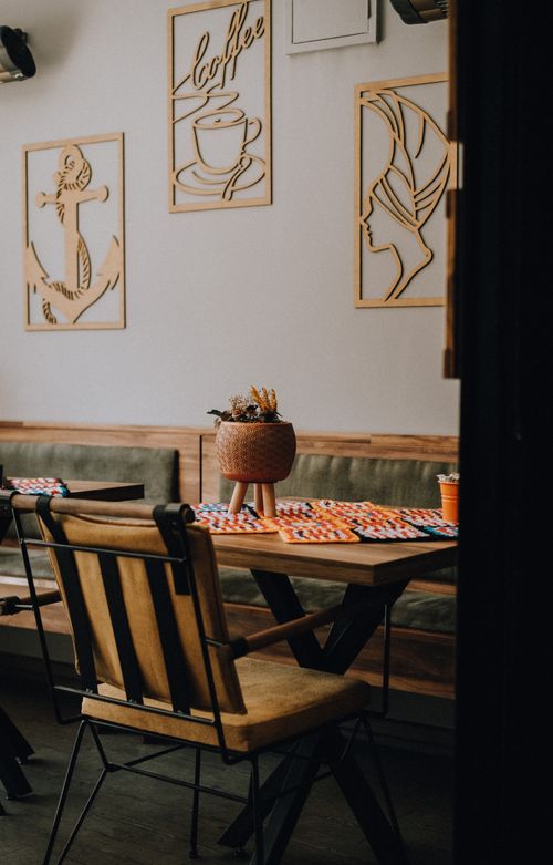 Free A warm and inviting cafeteria interior with artistic wall decor and stylish furniture. Stock Photo