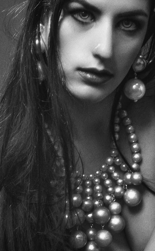 Grayscale Photo of Woman Wearing Beaded Necklace and Dangle Earrings