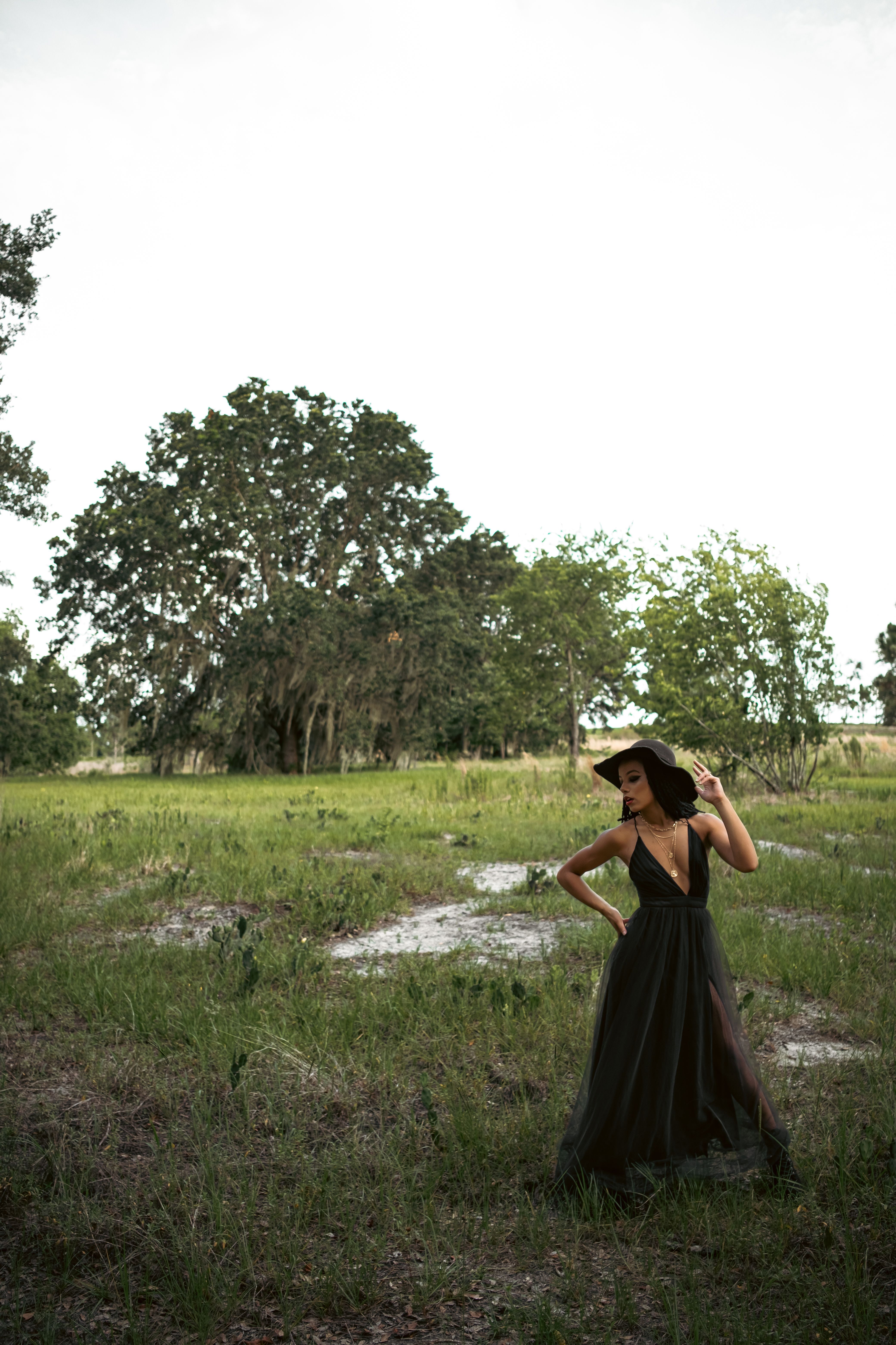 Woman in Black Dress Standing on Grass Field · Free Stock Photo