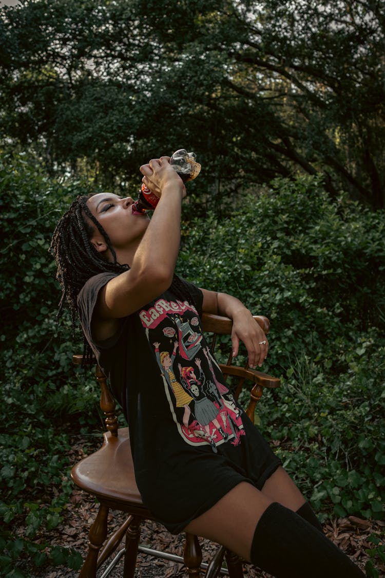 Woman In Black Shirt Drinking A Softdrink