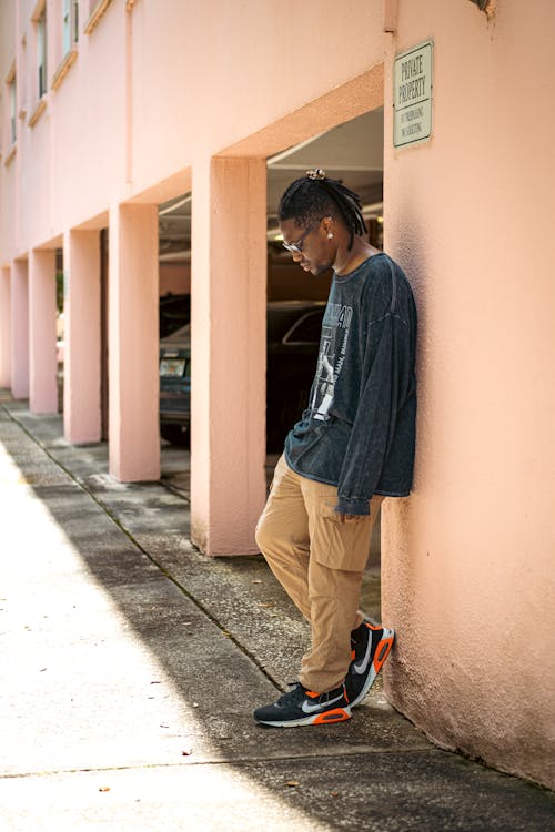 A Man in Gray Sweater Leaning on the Wall