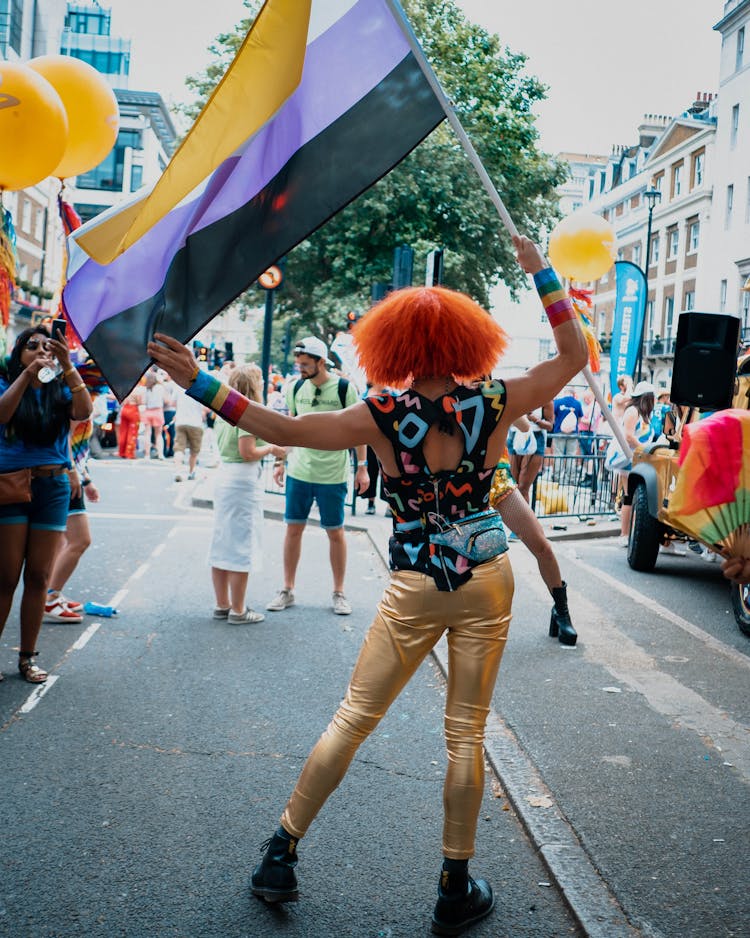 A Person With Dyed Hair Carrying A Flag