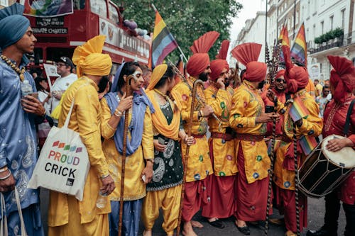 Free People in Yellow and Red Traditional Dress Standing on Street Stock Photo