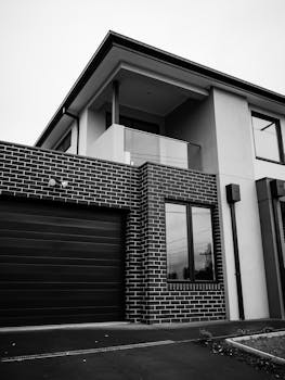 Stylish modern two-story house with architectural details in grayscale.