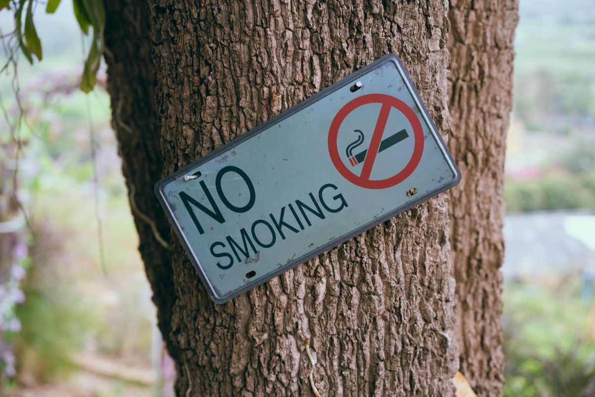 Placa de proibido fumar em área externa, reforçando a conscientização sobre o tabagismo