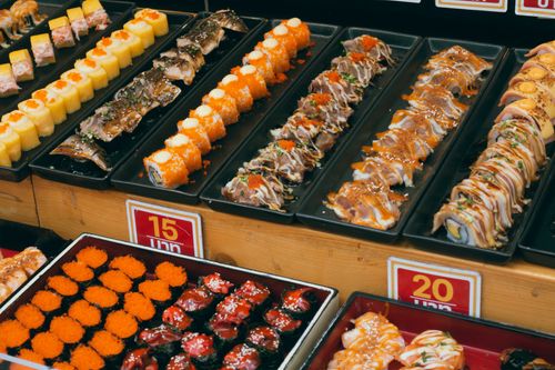 Free A colorful array of sushi platters at a buffet, showcasing assorted rolls and seafood delicacies. Stock Photo