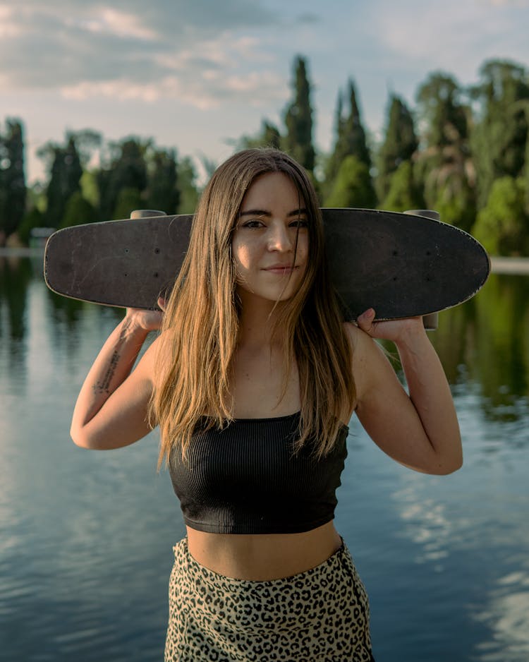 A Woman In Black Top Holding A Skateboard