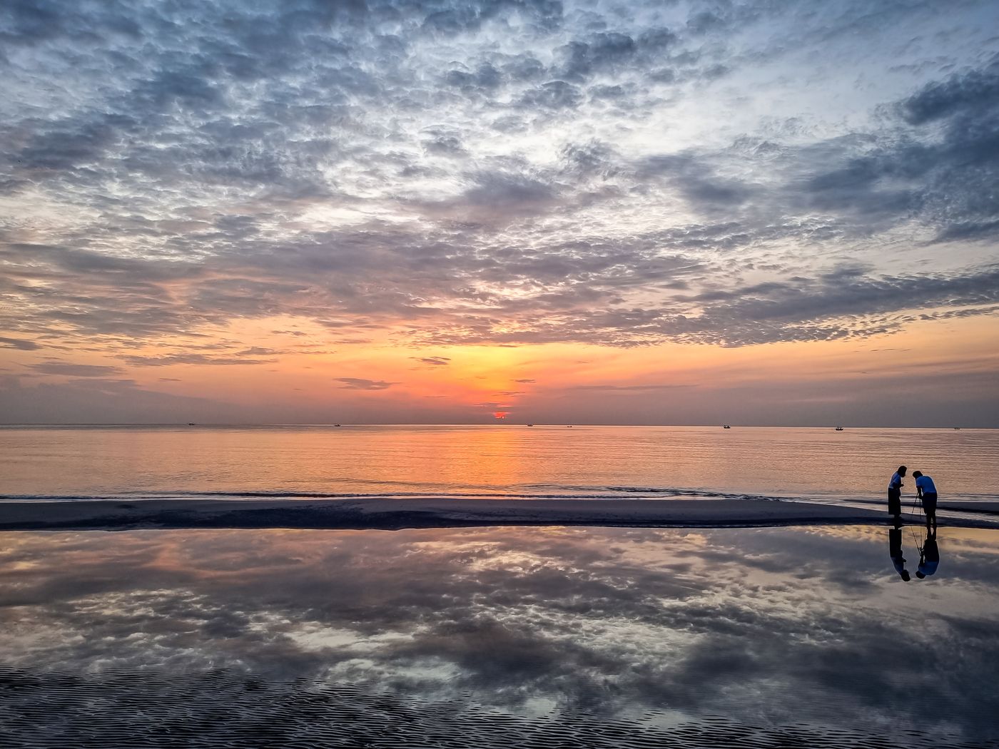 Sun low over Hua Hin Beach, reflected in the wet sand
