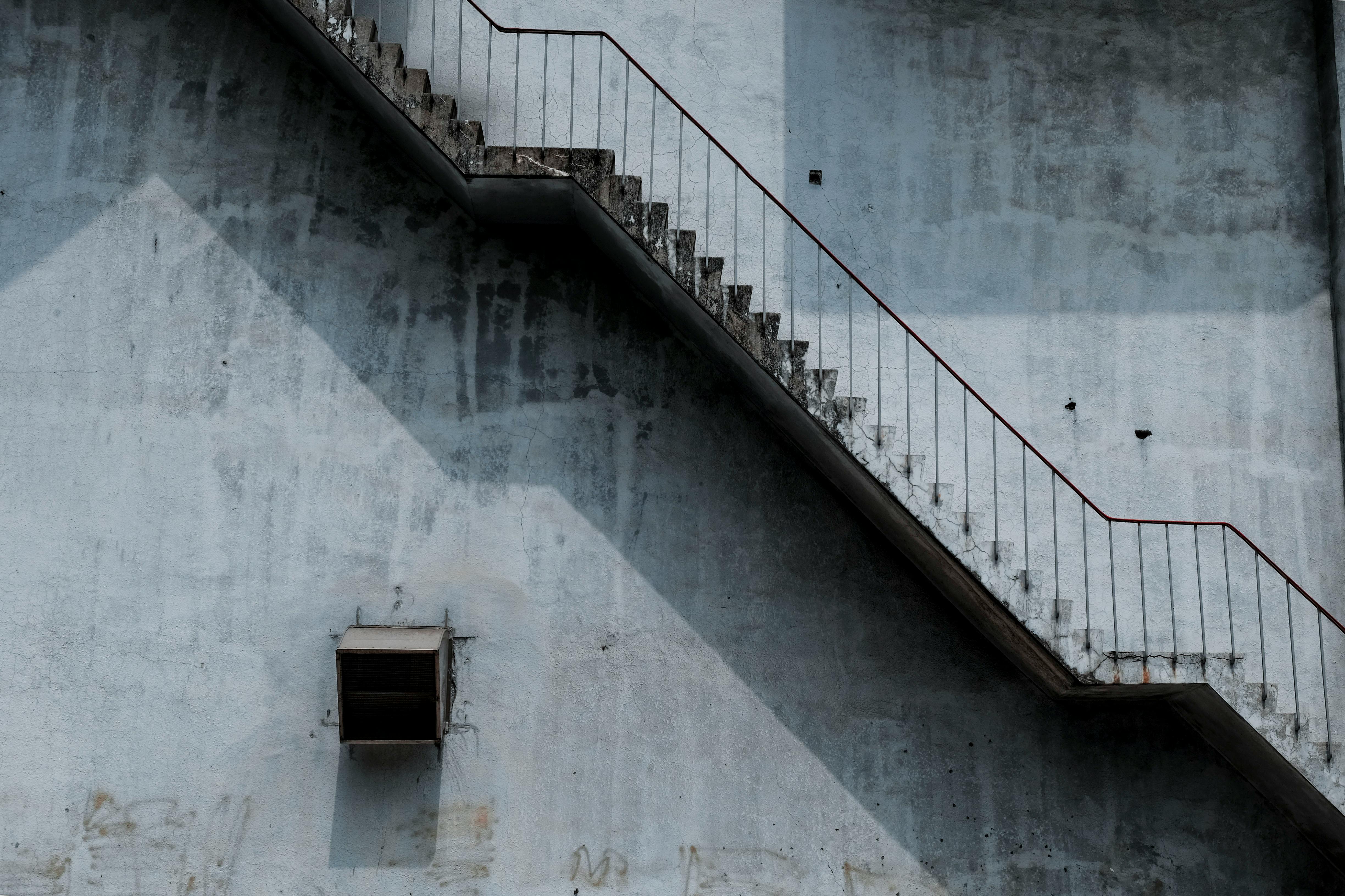 brown metal staircase and gray painted wall