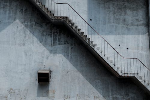Коричневая металлическая лестница и серая окрашенная стена