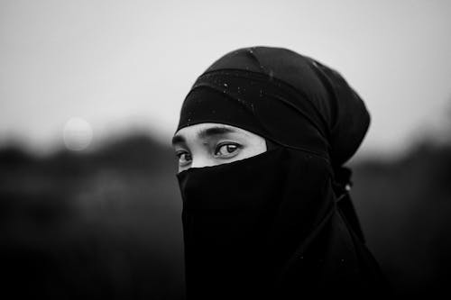 A Grayscale Photo of a Person Wearing Headscarf