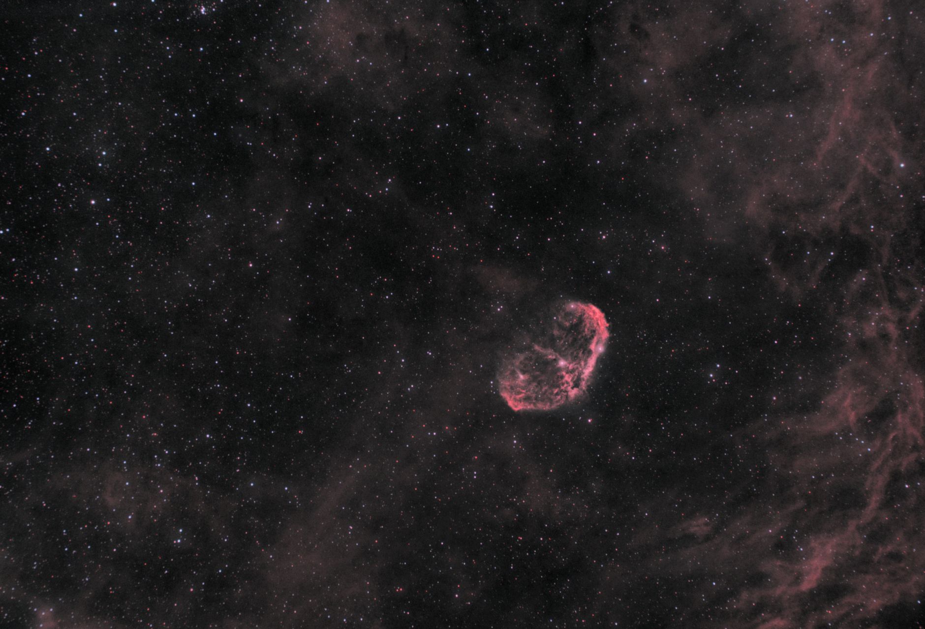 Captivating view of the Crescent Nebula surrounded by a star-filled cosmic night sky.