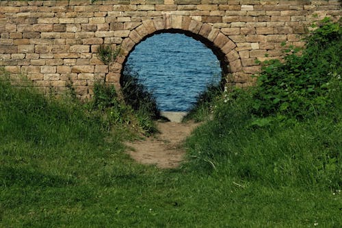 Free Arch in Brick Wall to River Stock Photo
