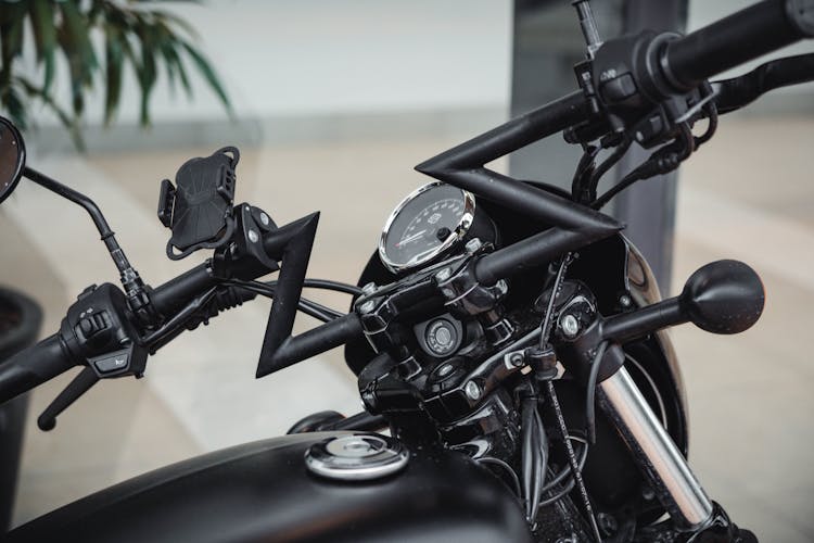 Black Handlebars Of A Motorbike With Phone Holder