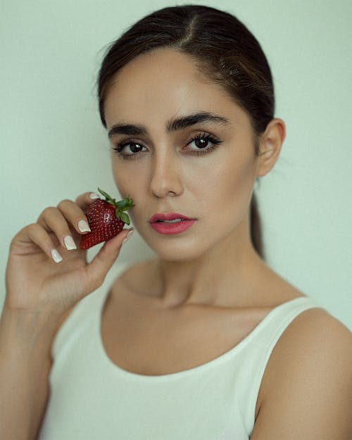 A Woman Holding a Strawberry