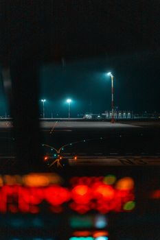 Night view of a quiet airport runway illuminated by street lights.