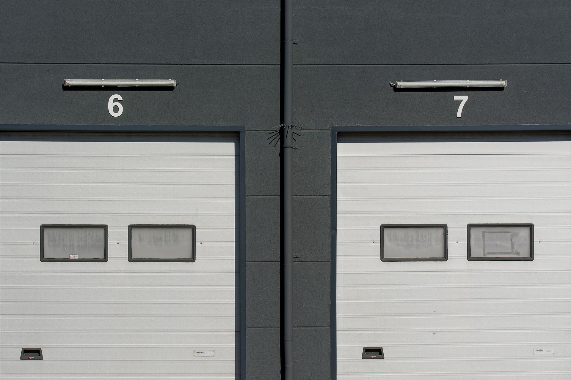 Close-up of modern garage doors numbered 6 and 7 on an industrial building facade.