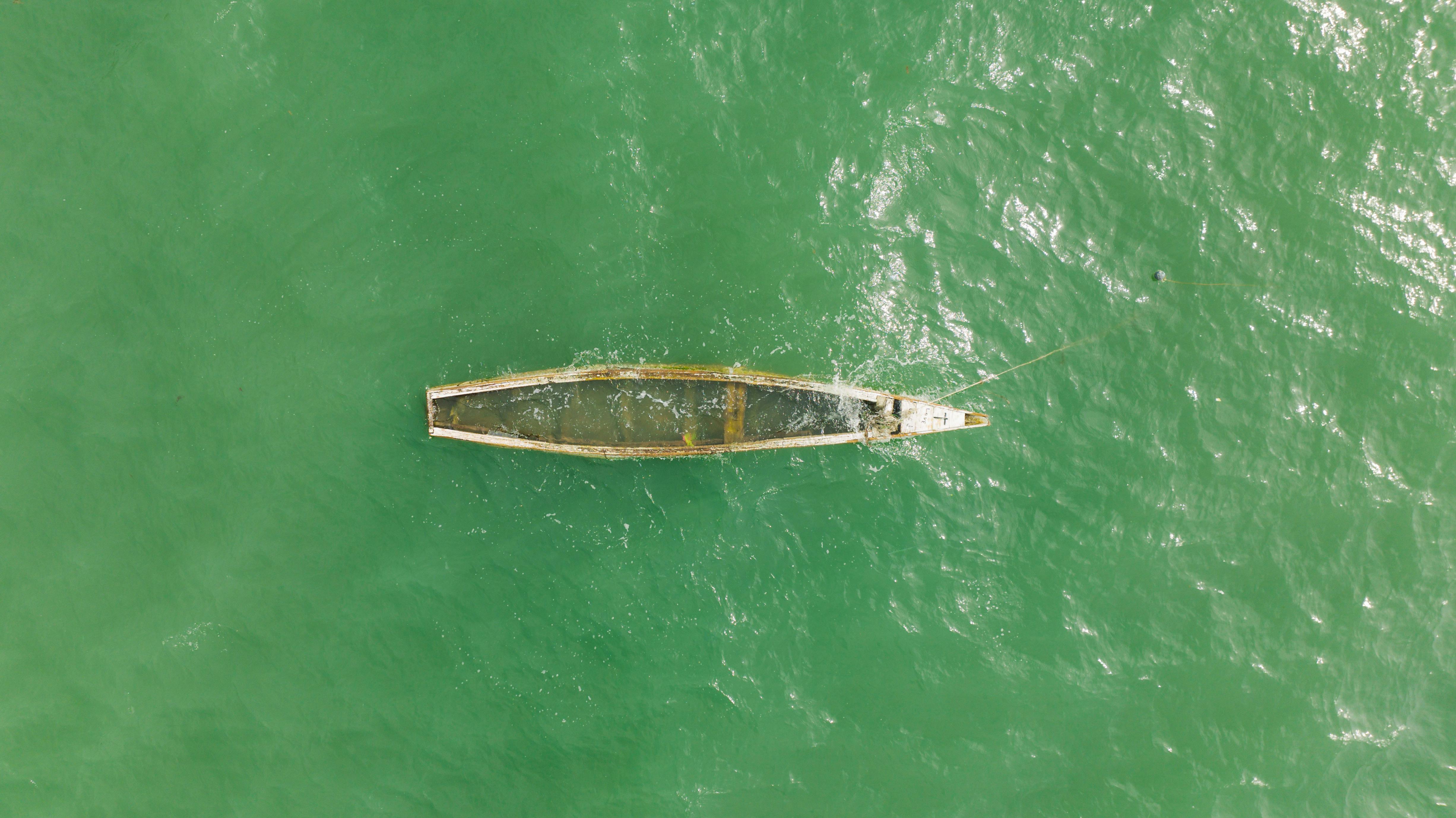 an aerial photography of a wooden boat on the sea