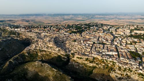 Free Stunning aerial view of a historic Italian town nestled among cliffs during summer. Stock Photo