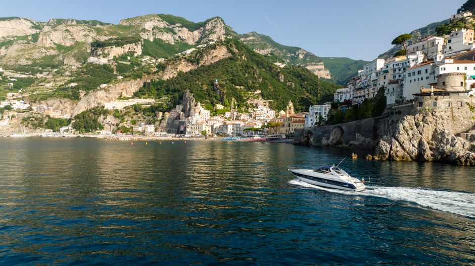 Best Tour to Figarolo Island with the Possibility to Observe Dolphins Review: A Complete Guide to This Unforgettable Sardinian Adventure Review 2026 - A yacht cruises along the picturesque Amalfi coastline under clear blue skies during summer.