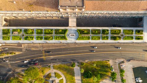 Free Overhead view showcasing a city garden next to a busy road intersection on a sunny day. Stock Photo