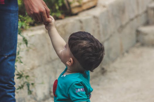 在叙利亚阿克拉巴特，一名幼儿牵着成年人的手，温馨的场景在户外展开