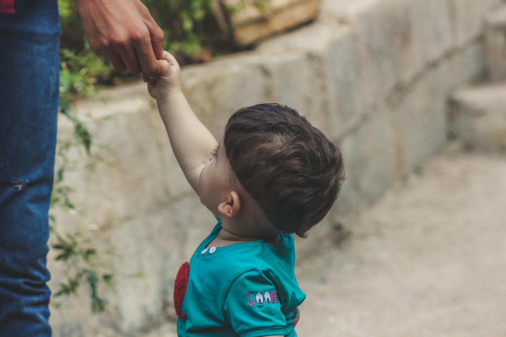 Photography of Baby Holding The Hand of Person