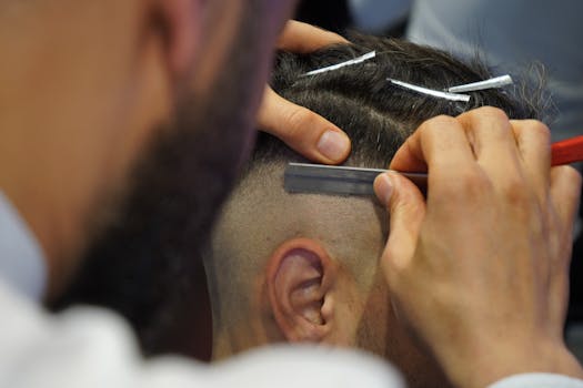 A barber uses a razor for precise grooming during a haircut in a modern barbershop.