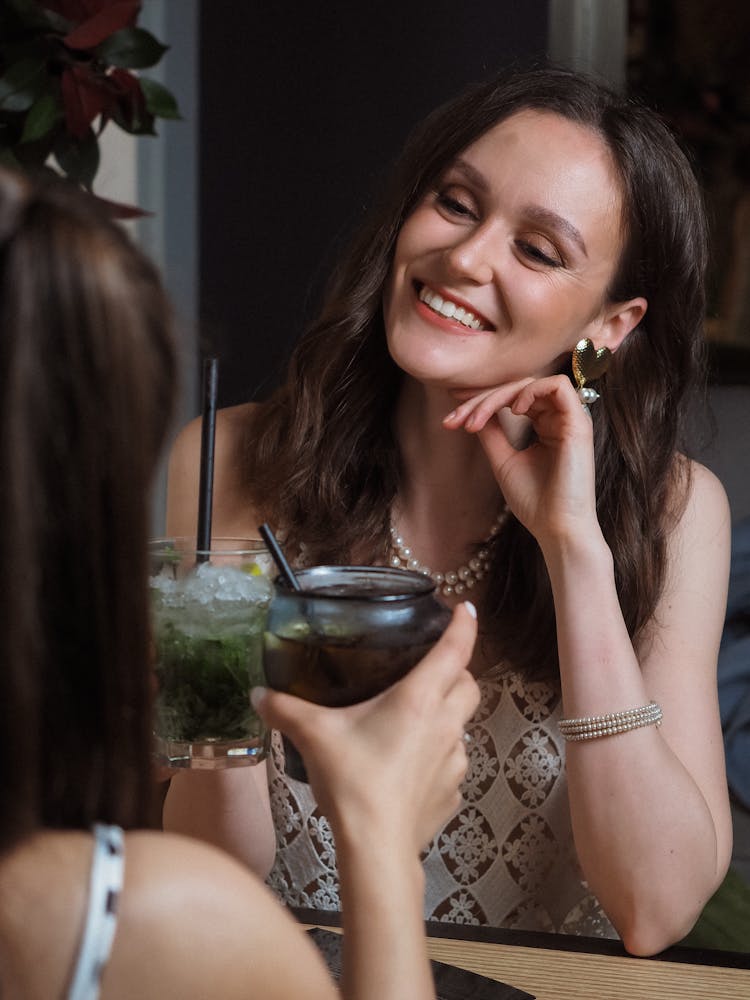 A Woman And A Person Holding A Glass Of Drink 