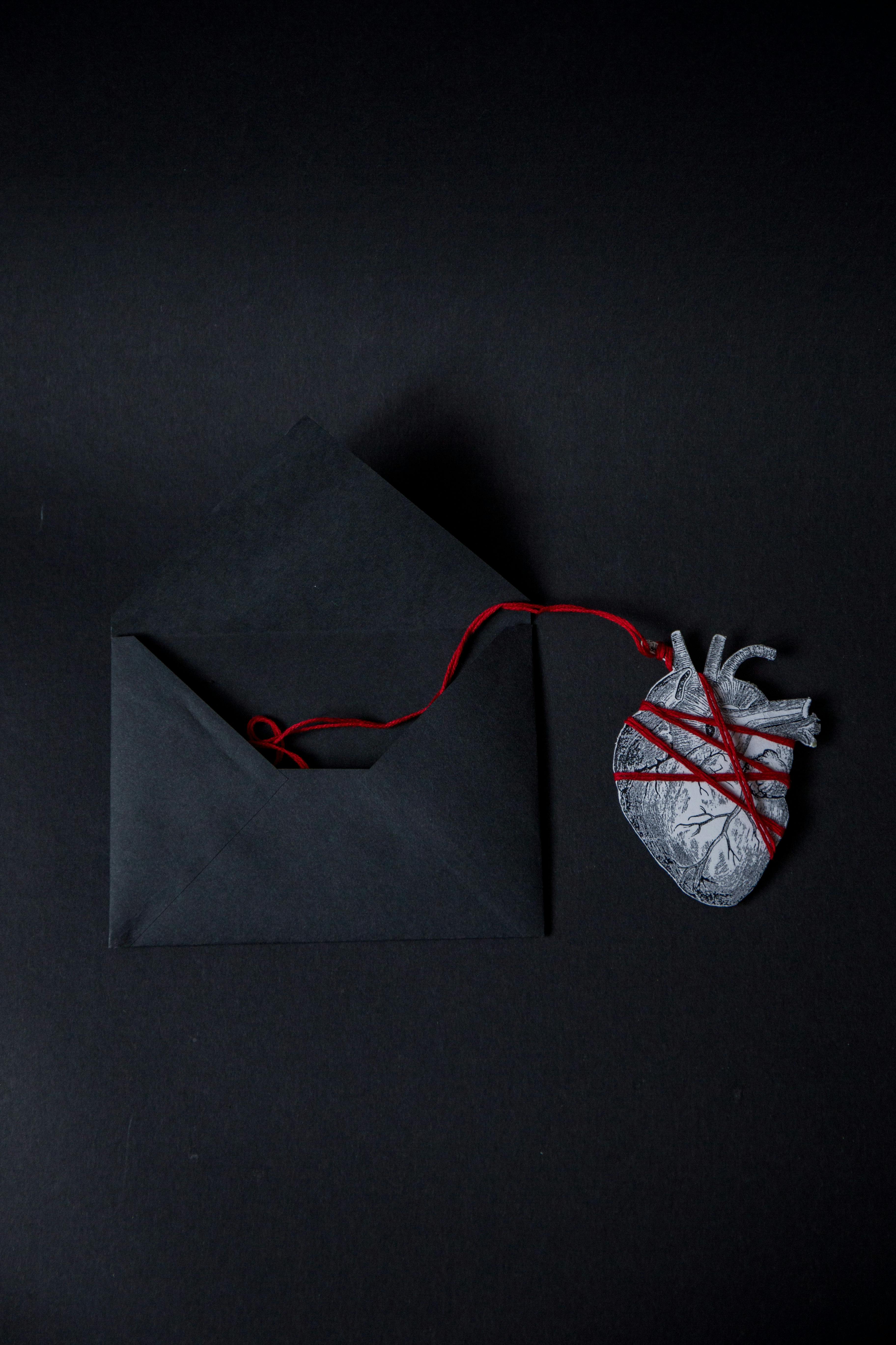 real heart paper cutout attached to an envelope with a string