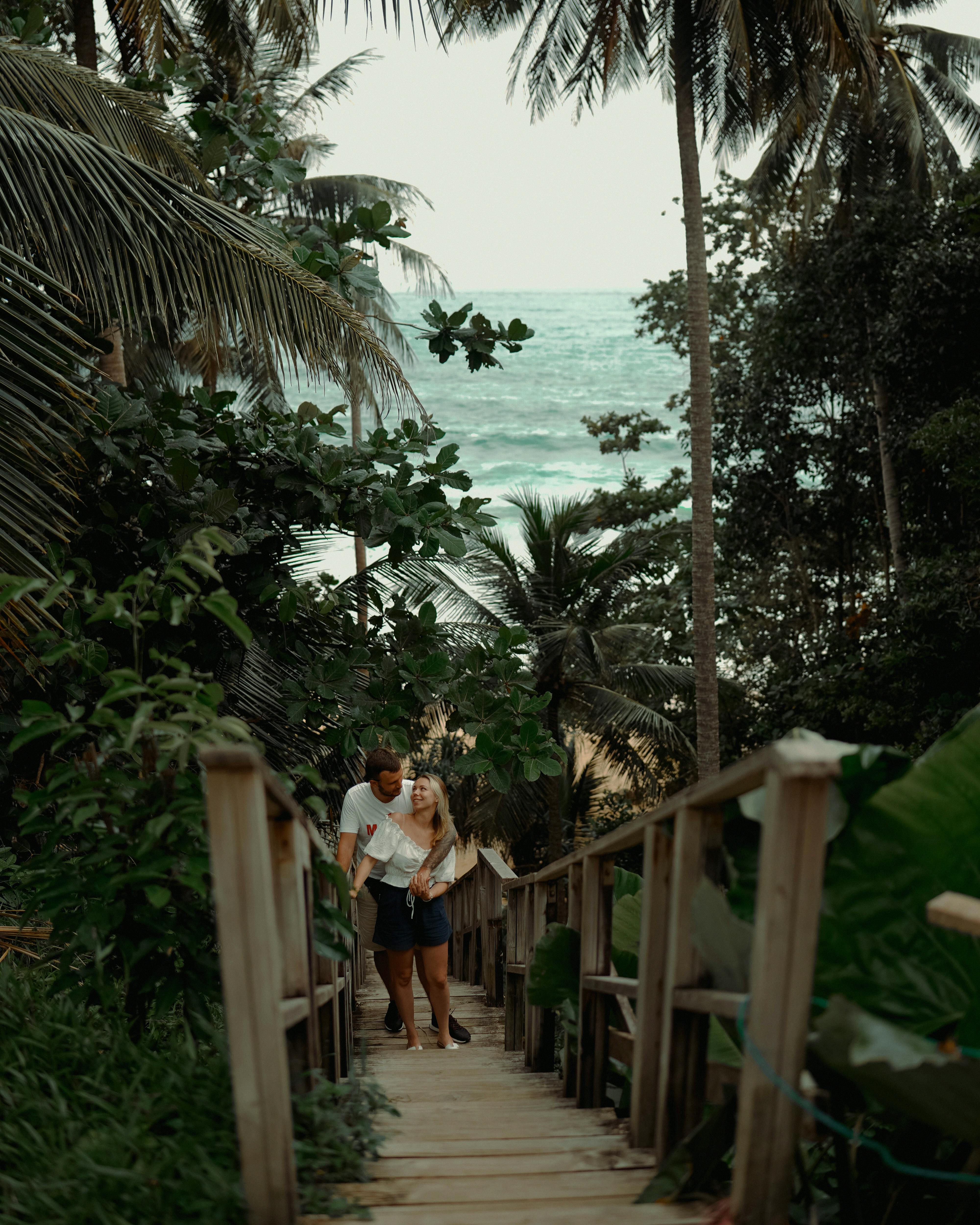 一对夫妇在泰国普吉岛的热带人行桥上浪漫漫步