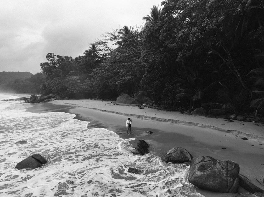 A couple enjoying a romantic walk on the serene shores of Phuket, Thailand.