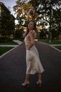 Woman in White Sleeveless Dress Standing on Gray Brick Floor