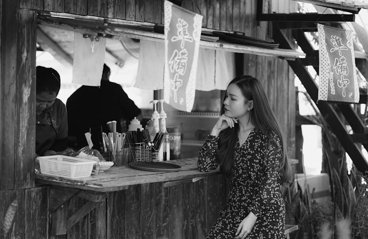 Woman Sitting At Bar In Street Restaurant