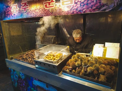 Outdoor food stall with a vendor selling roasted chestnuts at night, capturing warm ambiance.