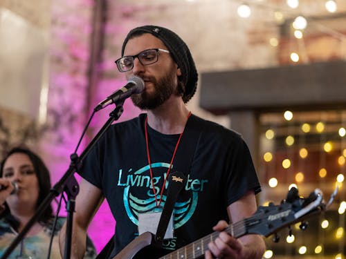 Bearded Man Singing and Playing a Guitar