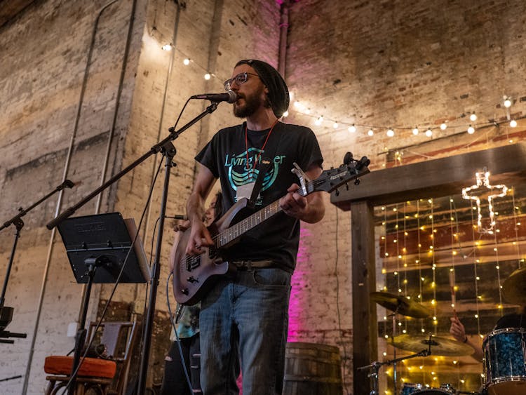 A Bearded Man Singing On Stage 