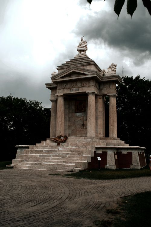 Free Majestic stone monument in Hungary surrounded by dark clouds, showcasing historic architecture. Stock Photo