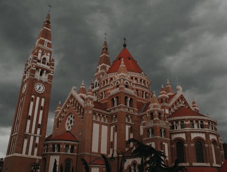 The iconic Votive Church in Szeged, Hungary under dramatic stormy skies.