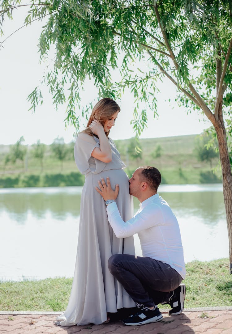 Man Kissing His Partner Pregnant Belly 