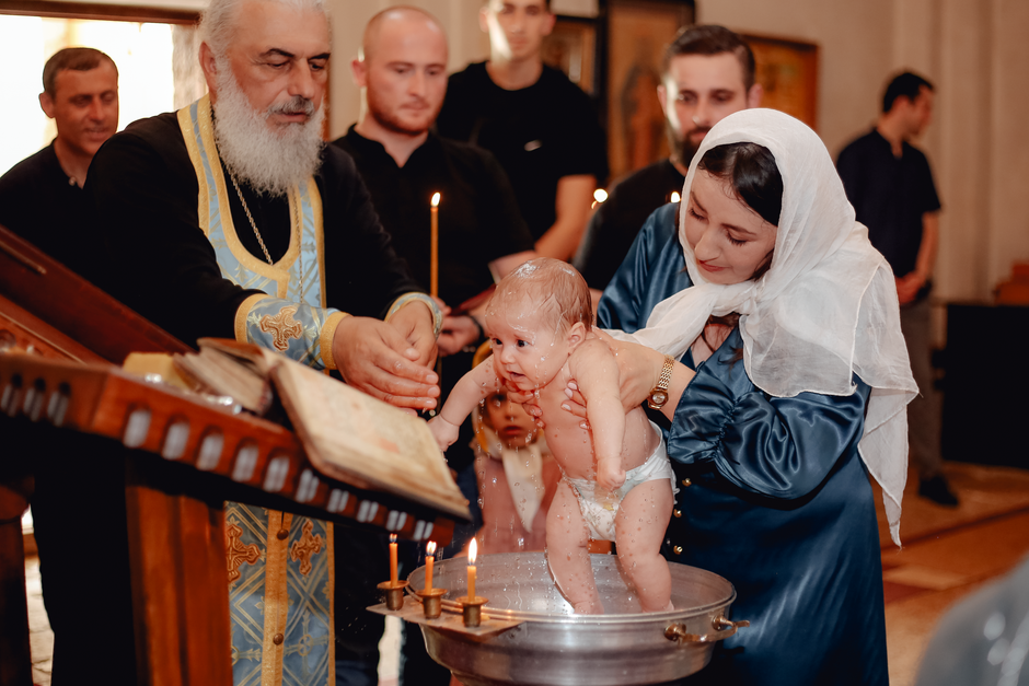 Familie la ceremonia de botez simbolizând comunitatea și binecuvântarea