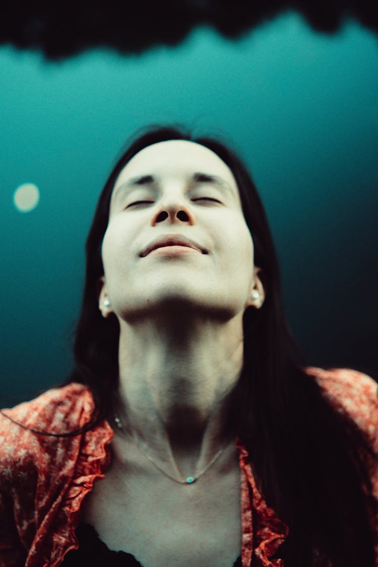 Portrait Of Woman With Head Up And Lake In Background