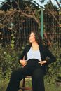 Woman in Black Cardigan Sitting on Brown Wooden Bench