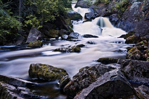 River Flowing Through Mossy Rocks
