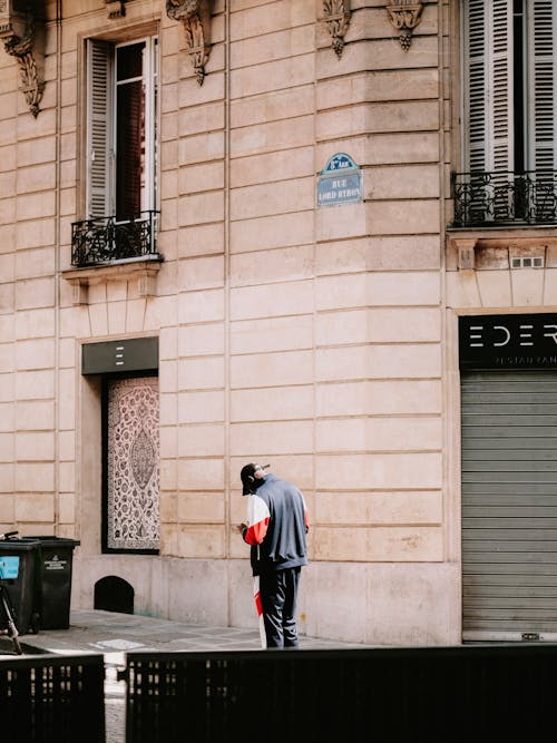 Free Man in Jacket and Pants Standing Beside a Building  Stock Photo